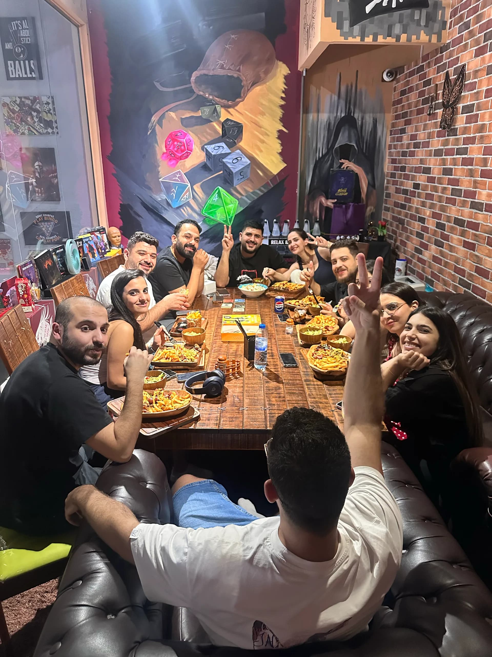 A long table of players eating together in the Dungeons & Dragons room at Spartacues